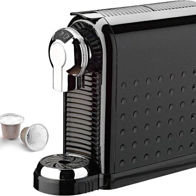 Machine à café à capsules compacte de couleur noire avec des accents argentés et des dosettes de café environnantes, parfaite pour la préparation de café à domicile.