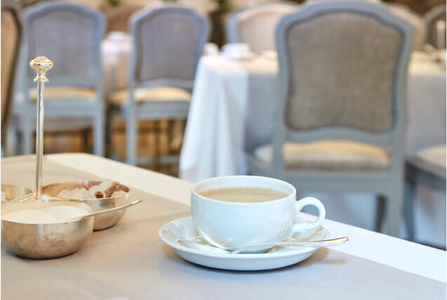 Élégante tasse à café sur une table de l'hôtel Daboven, avec un set de sucre et de crème, créant une atmosphère chaleureuse pour les invités.