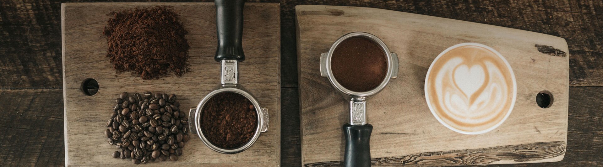 Freshly ground coffee and beans paired with a beautifully crafted latte art on wooden serving boards.