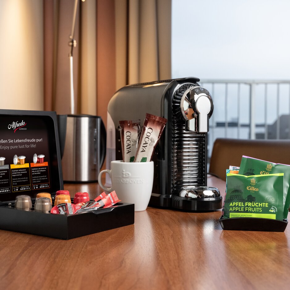 Kaffeestation im Hotelzimmer mit Nespresso-Maschine, Espresso-Pads und Snacks für den Komfort der Gäste.