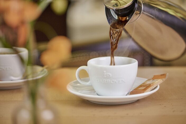 Pouring aromatic coffee into a white cup, showcasing luxury filter coffee for the gastronomy sector.