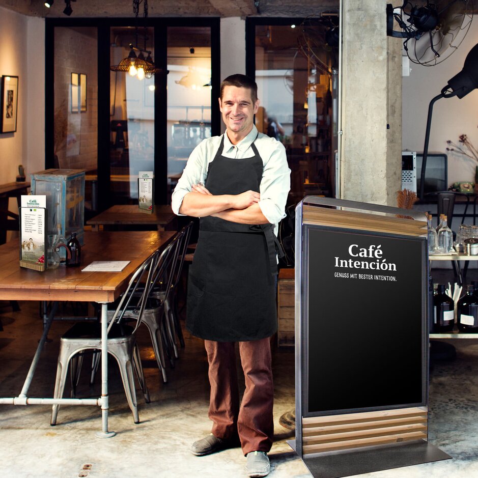 Einladende Cafészene im Café Intención mit Markenzeichen und einem freundlichen Barista, der bereit ist, die Kunden zu bedienen.