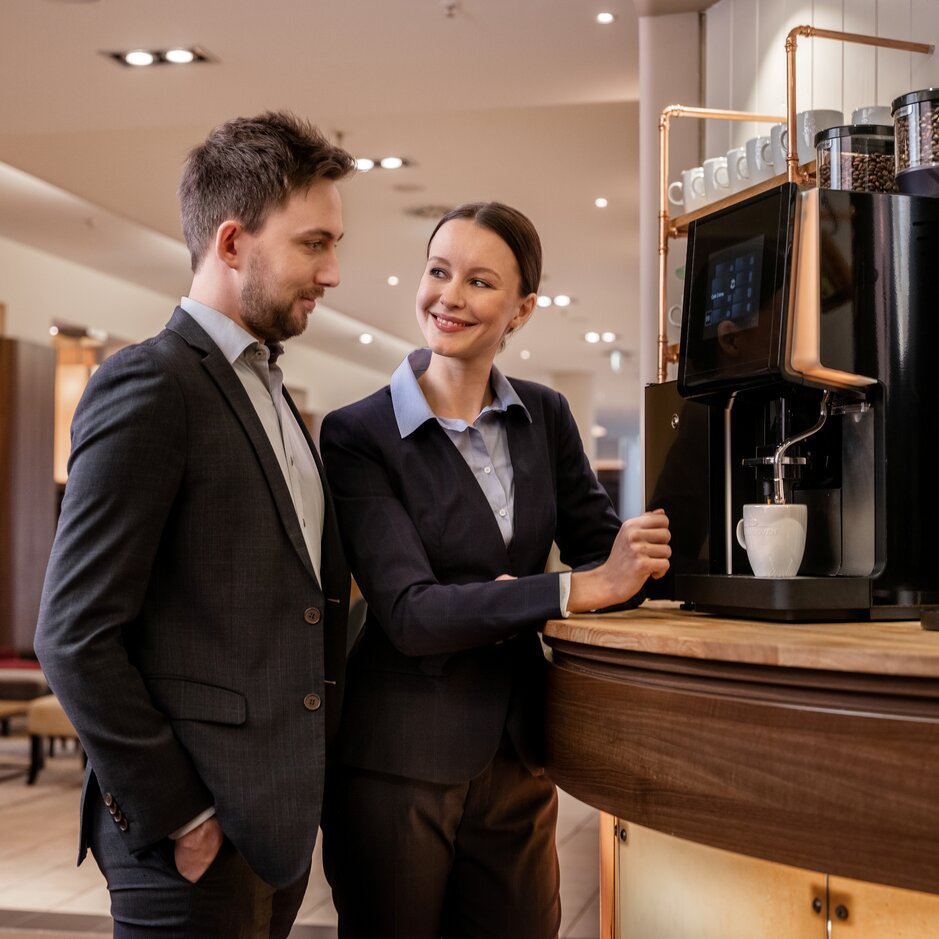 Obchodníci si vychutnávajú kvalitnú kávu v štýlovej kaviarni, ktorá vyniká moderným kávovým vybavením a pohostinnosťou.