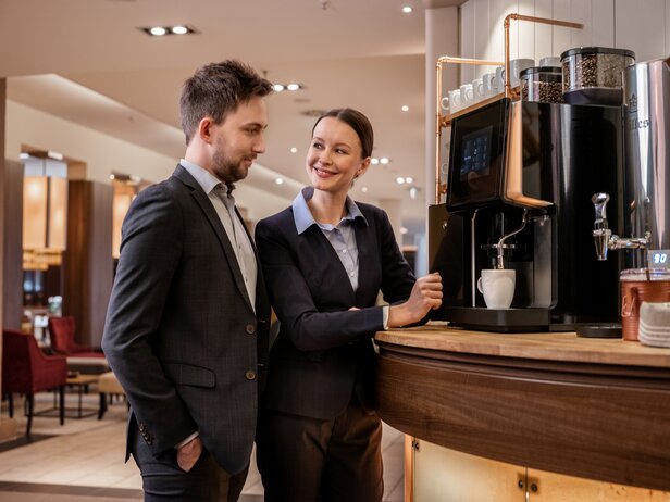 Profesjonaliści biznesowi delektujący się wysokiej jakości kawą w stylowej kawiarni z nowoczesnym sprzętem kawowym i gościnnością.