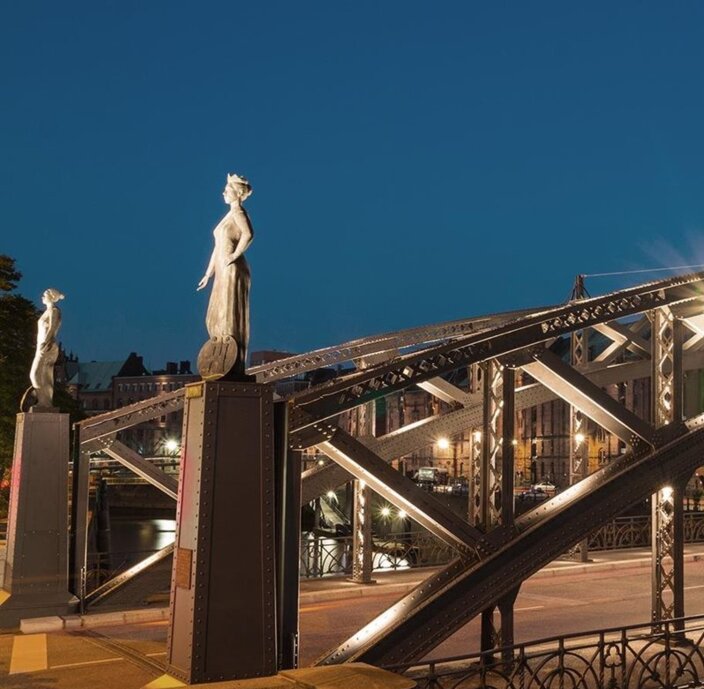 Brookův most v Hamburku, který je v noci krásně osvětlený a na obou koncích má elegantní sochy, které dokládají architektonický půvab.