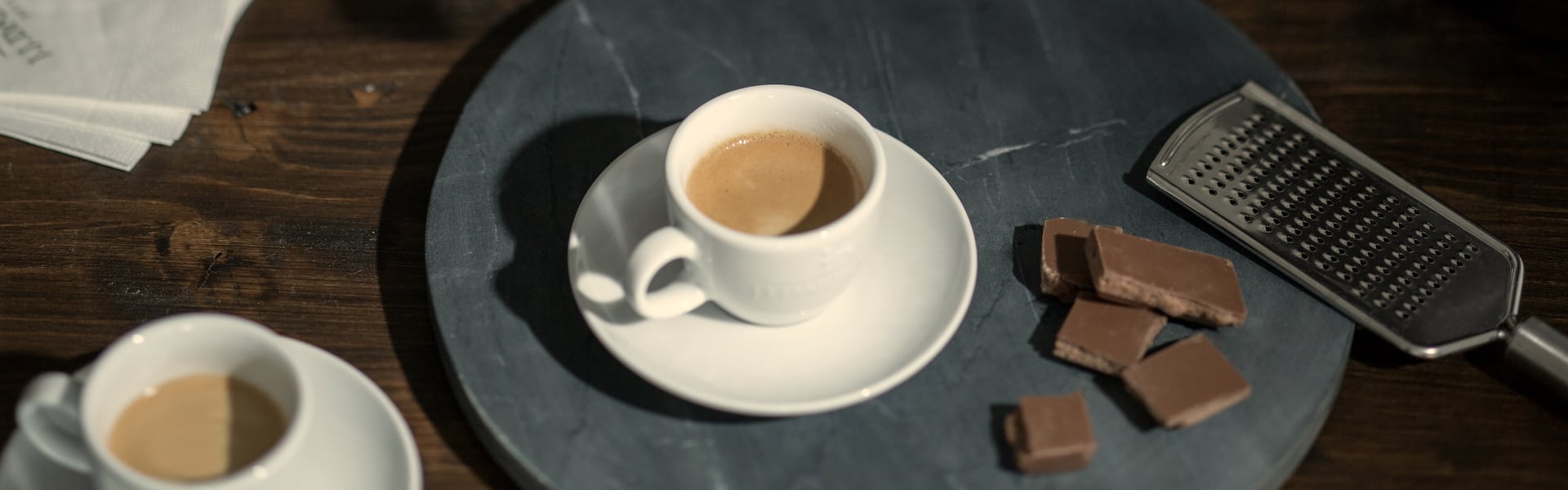 J.J. Darboven Mood Bild – Kaffeetasse, Schokolade und Raspel auf Teller
