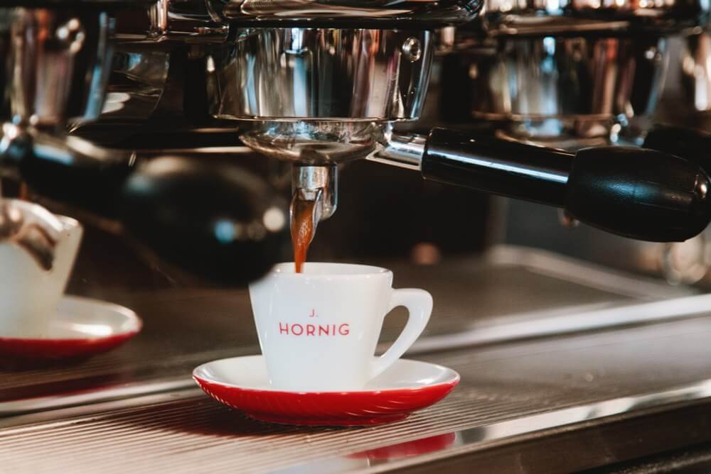 J. Hornig Kaffee - Tasse wird mit Kaffee gefüllt