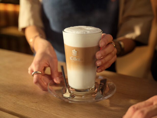 Delicious latte served in a stylish glass, showcasing creamy froth and rich layers, perfect for coffee lovers.