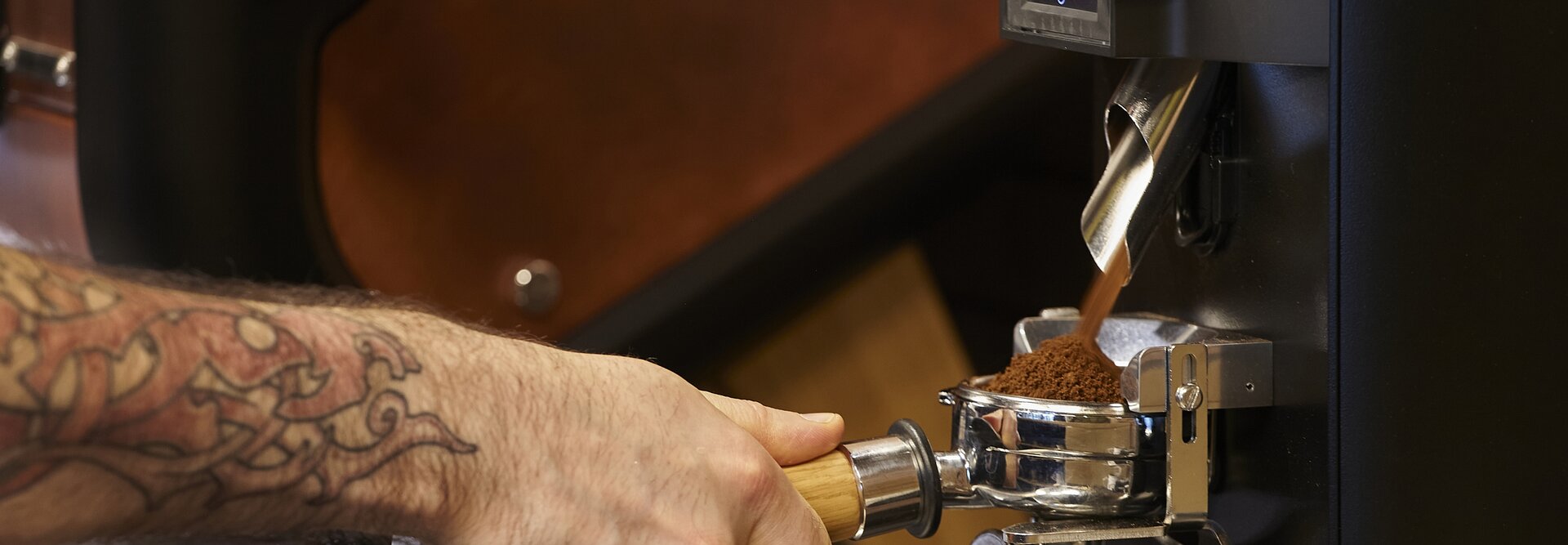 Barista przygotowujący świeżo zmieloną kawę za pomocą profesjonalnego ekspresu do kawy, aby uzyskać bogaty i aromatyczny napar.