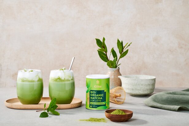 Delicious organic matcha lattes displayed with a can of bio matcha and elegant tea accessories, perfect for tea lovers.